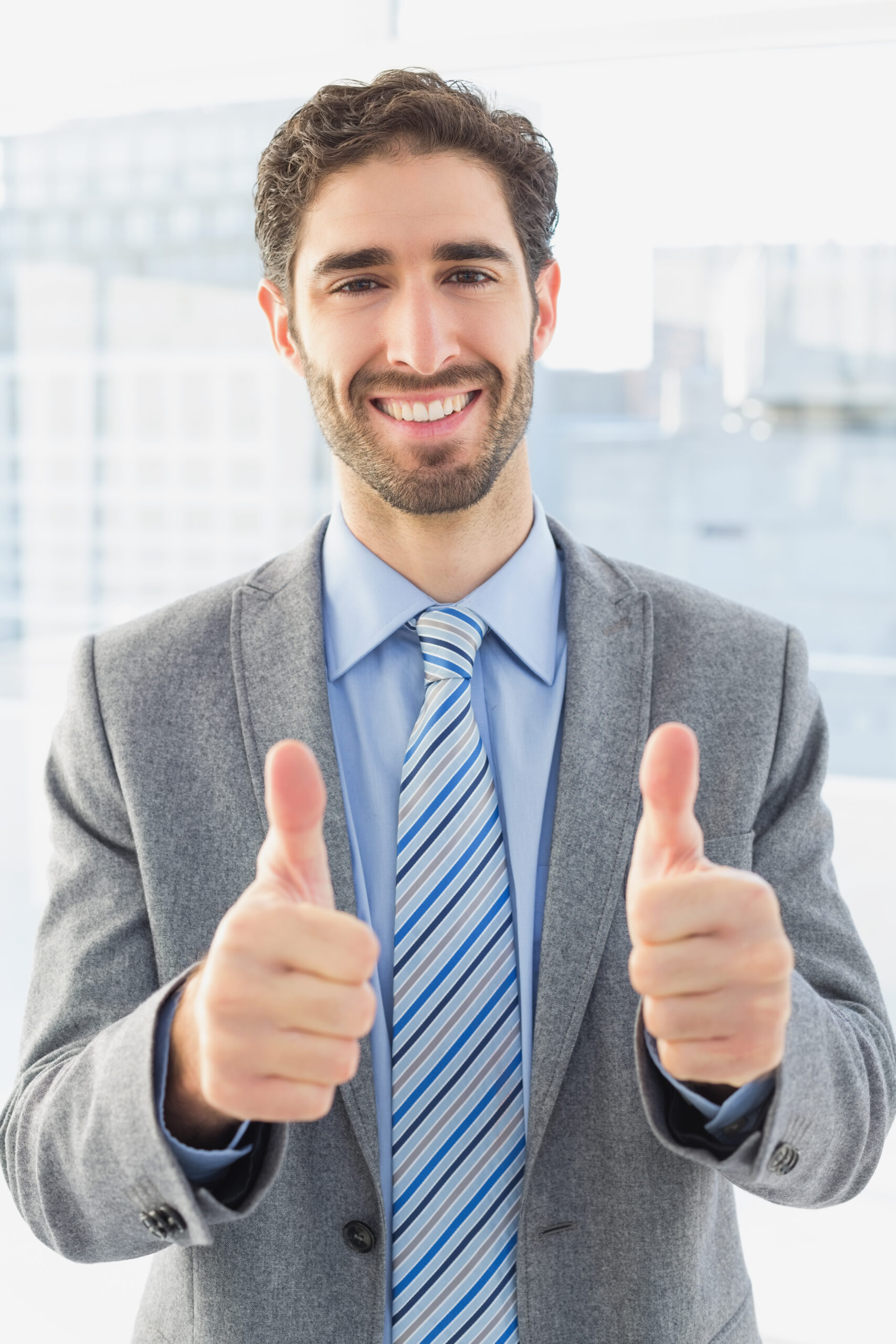 Businessman giving a thumbs up while at work